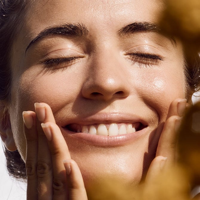 young woman washing her face smiling